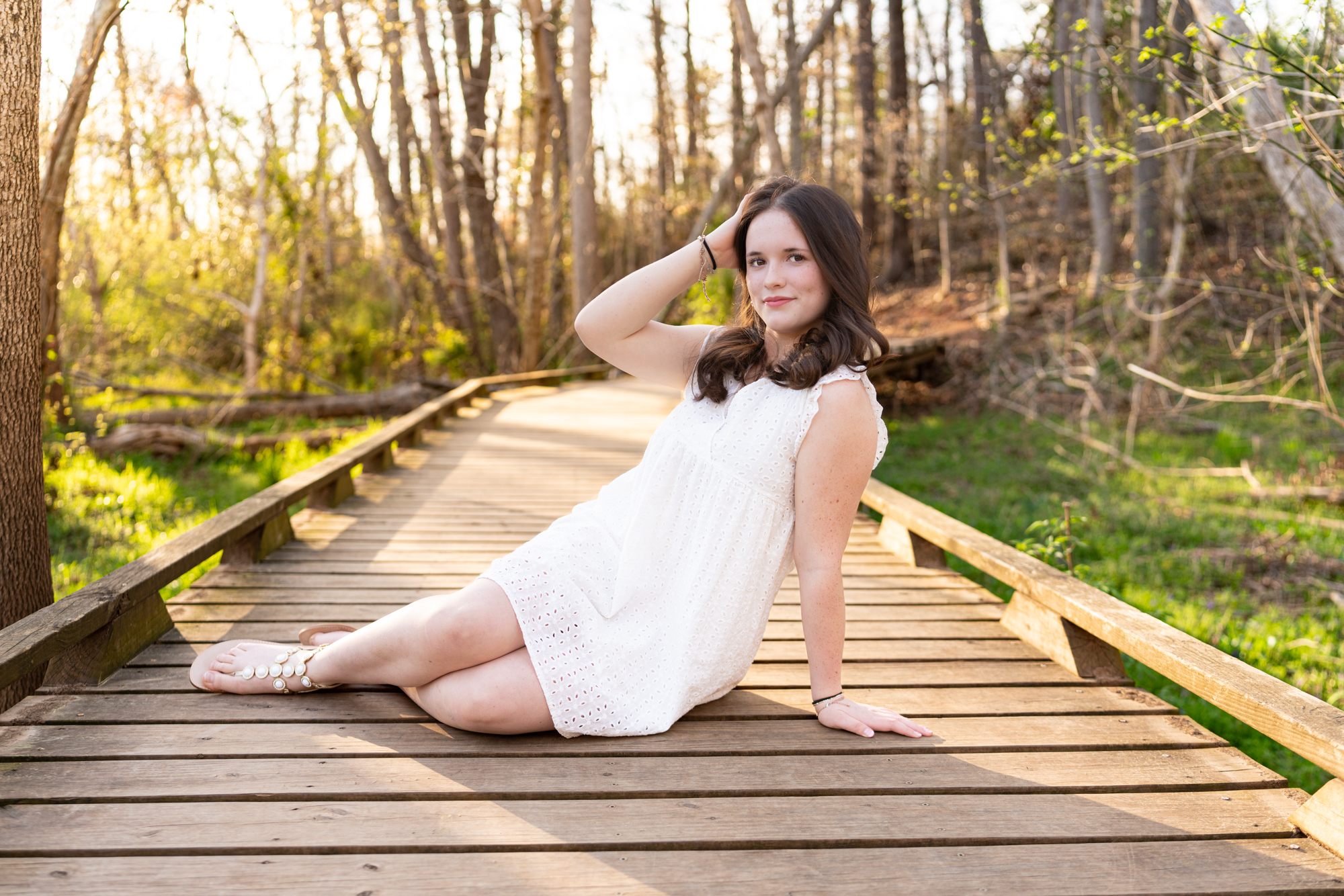 high school senior girl sits for a pose on boardwalk at Conestee Nature Trail for family session for best version media's Simpsonville Neighbors Magazine taken by Taylor Johnson Photography