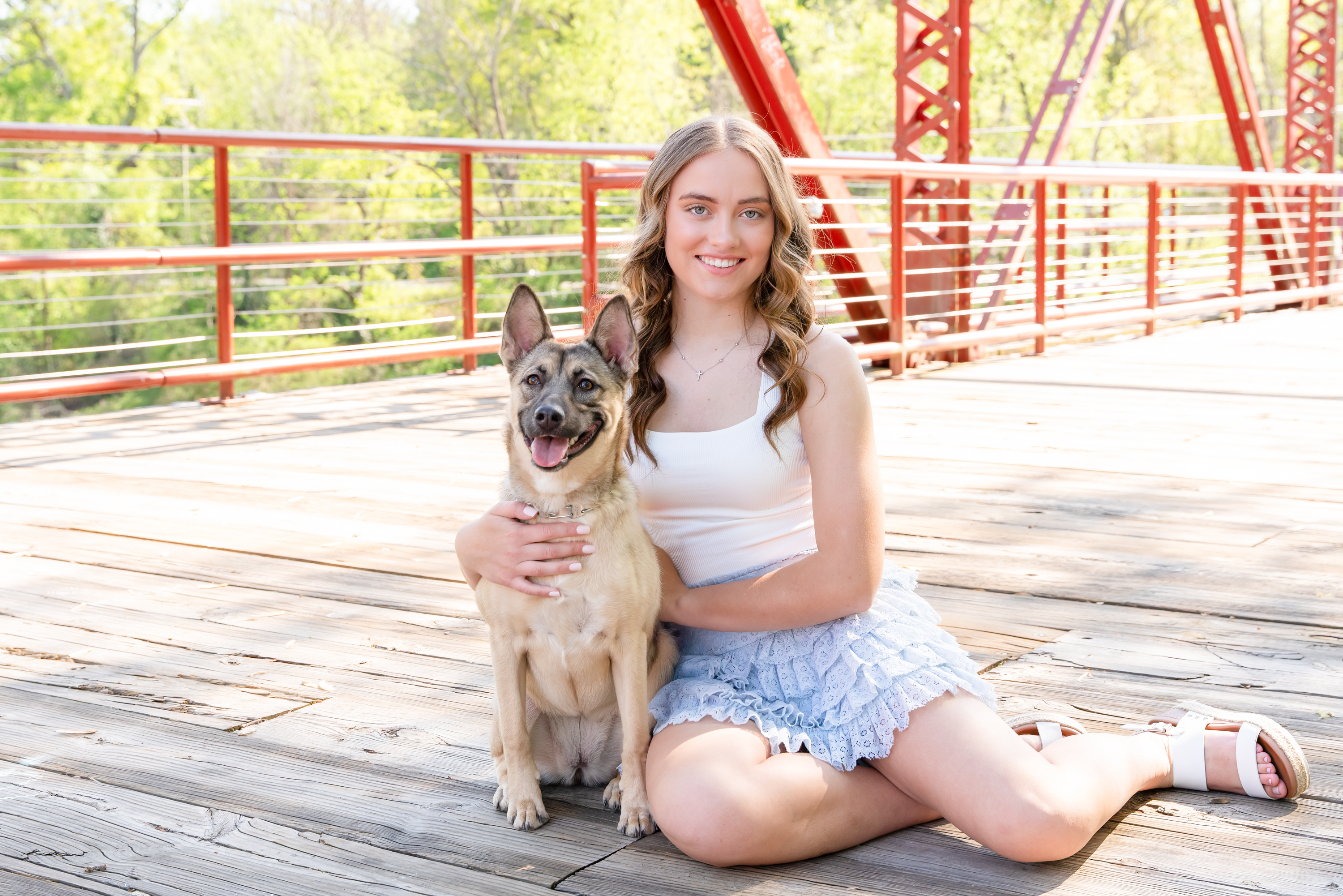 Broome high school senior girl sits for a pose with dog on industrial bridge at Glendale Shoals in Spartanburg County for high school senior pictures taken by Taylor Johnson Photography