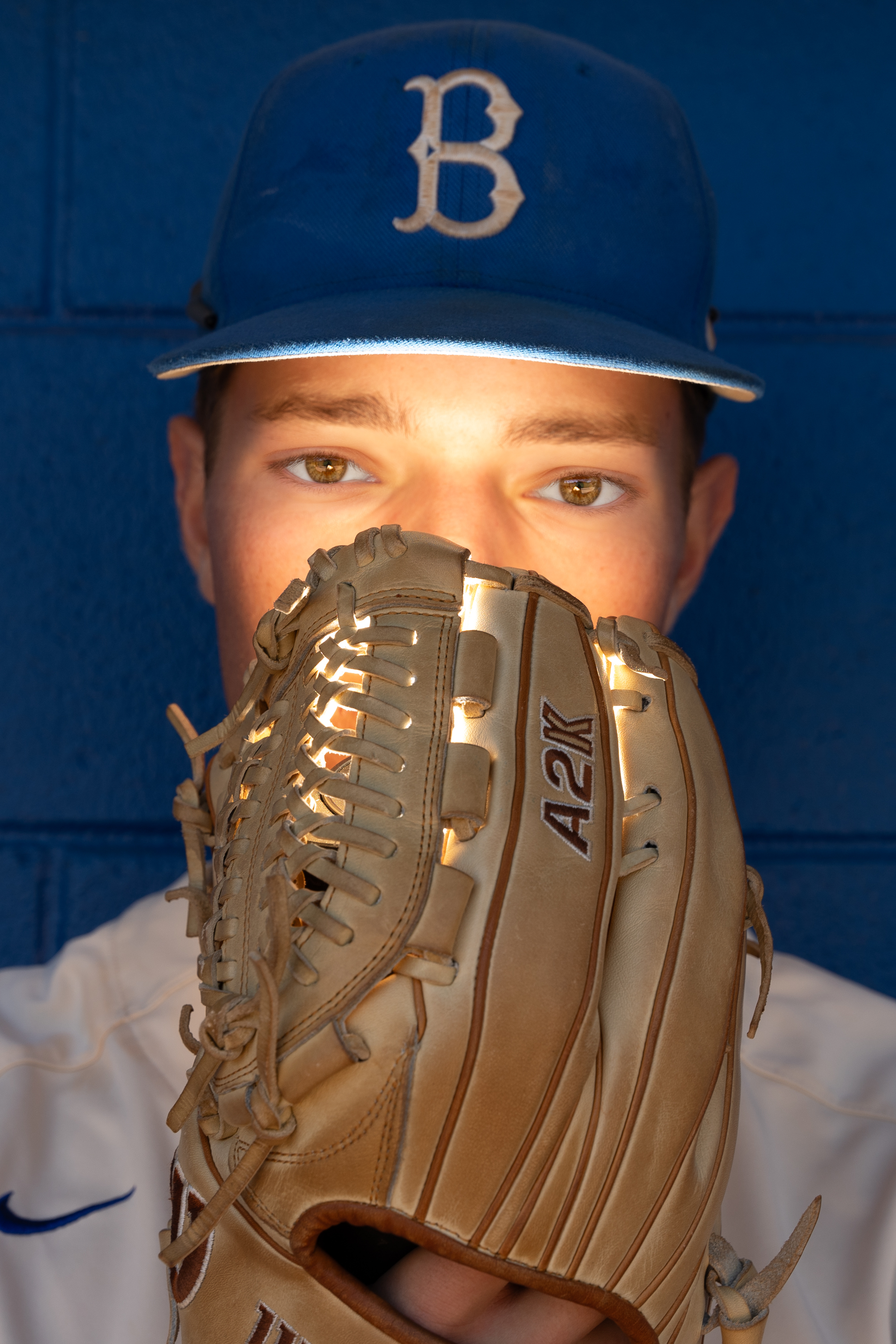 Byrnes Baseball player posing with baseball glove for senior pictures taken by Taylor Johnson Photography at the Byrnes Baseball field