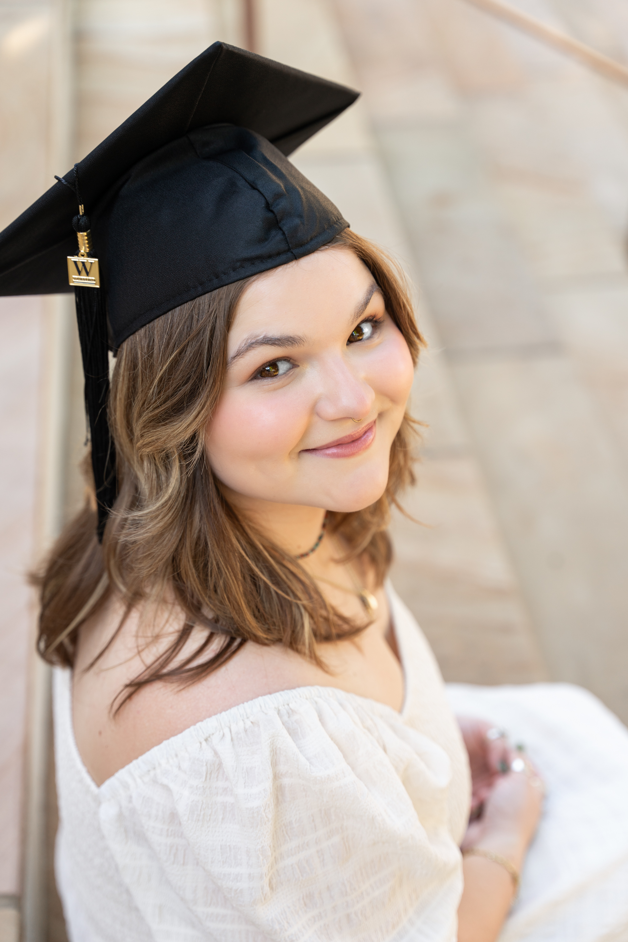 Wofford senior graduate posing with graduation dress and cap for senior photos at the Wofford campus taken by Taylor johnson photography